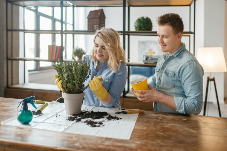 Young couple changes the soil in home plants